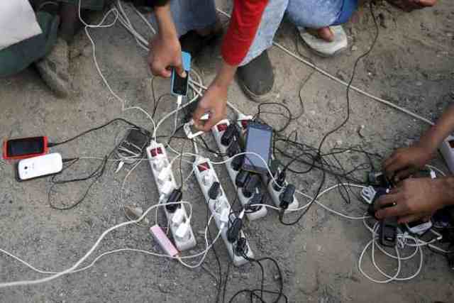 Afgánok tölti telefonjaikat Calaisnál - Fotó - New York Times