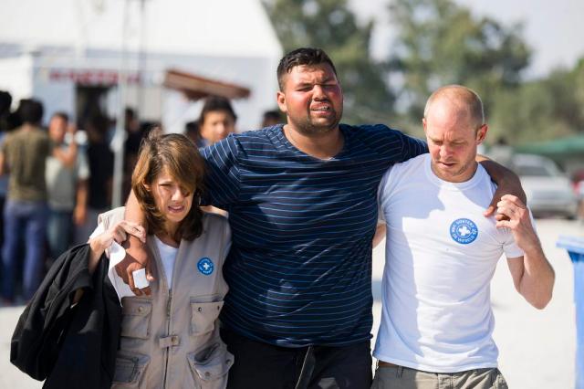 Moria, 2015. október 6. Önkéntesek segítenek egy migránsnak egy afgánoknak elkülönített táborban a görög Leszbosz szigetén Moria közelében 2015. október 6-án. MTI Fotó: Balogh Zoltán