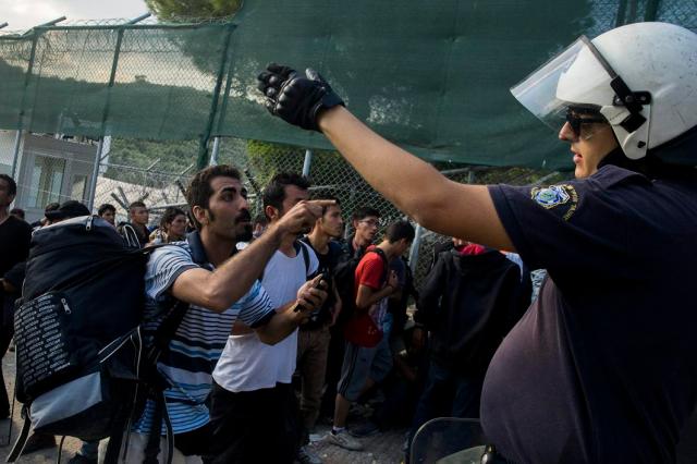Moria, 2015. október 6. Migránsok és egy rendõr vitáznak egy afgánoknak elkülönített táborban a görög Leszbosz szigetén Moria közelében 2015. október 6-án. MTI Fotó: Balogh Zoltán