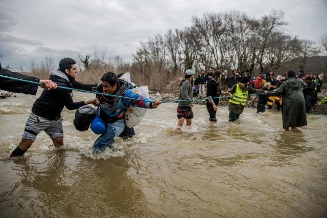Idomeni, 2016. március 15. Migránsok átkelnek egy folyón a görögországi Idomeni és a macedóniai Gevgelija között 2016. március 14-én. MTI Fotó: Balogh Zoltán